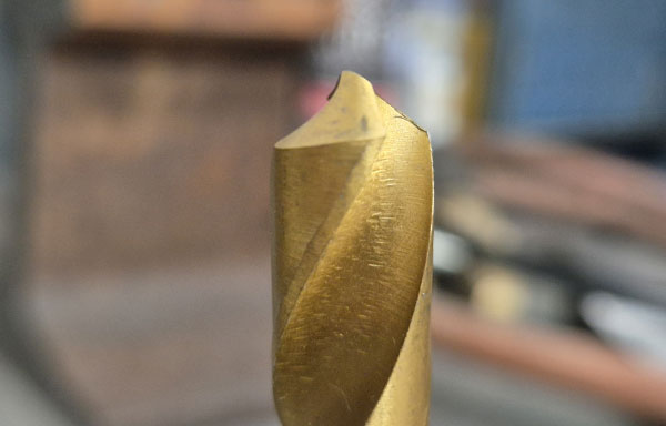 Selection of drill bits laid out on a workbench to illustrate the article on selecting the right drill bit for the job